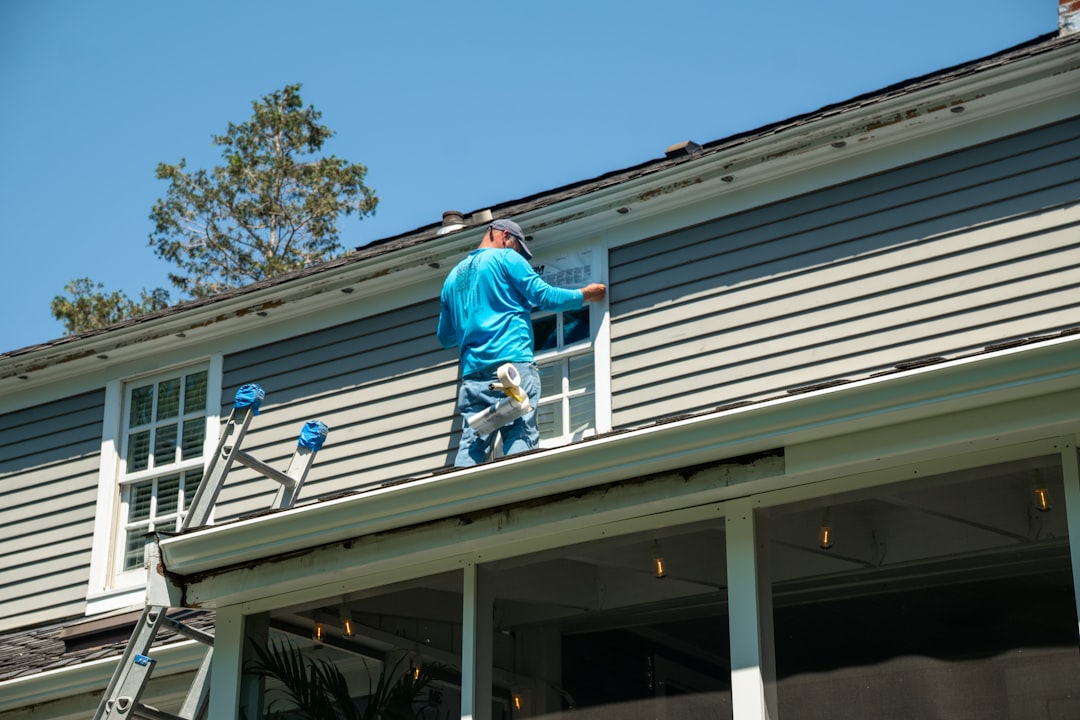 Professional roofing crew installing residential roof shingles with safety equipment