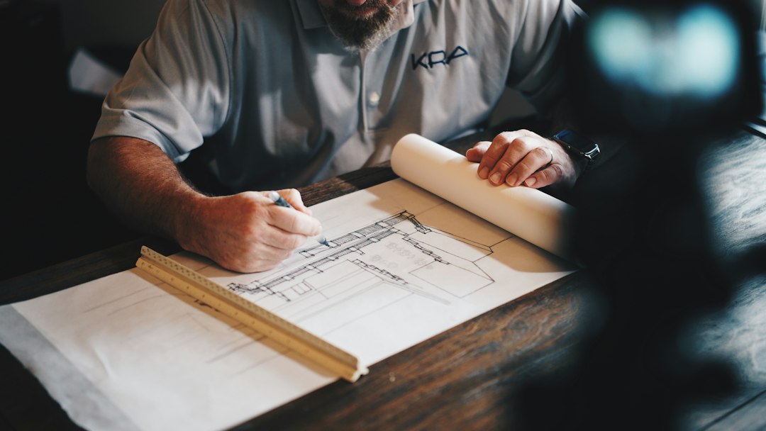 Professional contractor discussing financing options at desk with blueprints